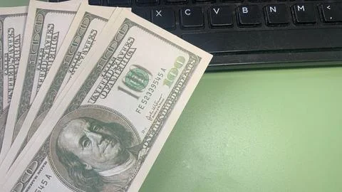 Several US hundred dollar bills placed near a computer keyboard, Stock Photos