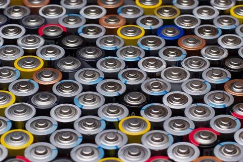 Several used stacked AAA batteries of different colors and manufacturers Stock Photos