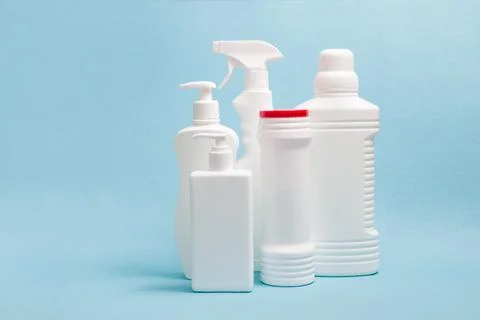 Several white plastic bottles without labels with cleaning products on a blue Stock Photos