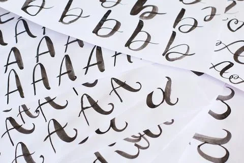 Several white sheets with calligraphic exercises. Calligraphy practice. Stock Photos