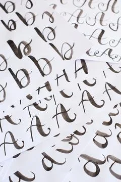 Several white sheets with calligraphic exercises. Calligraphy practice. Stock Photos