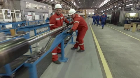 Several workers at an assembly plant working with pipe for petroleum industry Stock Footage 62085815