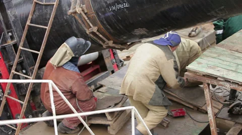 Several workers inspect a large pipe Stockbeeldmateriaal 36167982
