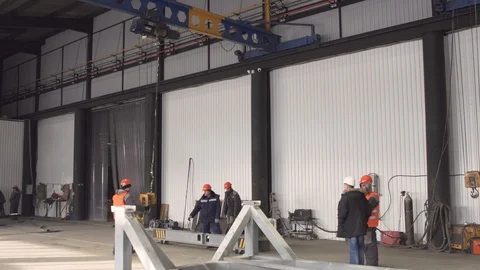 Several workers raise a beam on a crane. 4K Stock Footage 104656949