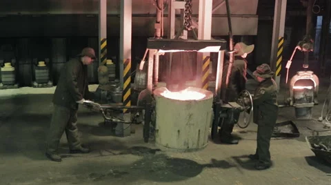 Several workers works with liquid iron in hot condition Stock Footage 62083277