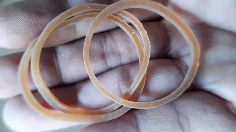 Several yellowish brown elastic rubber bands placed on a human palm shown i.. Stock Footage 324825035