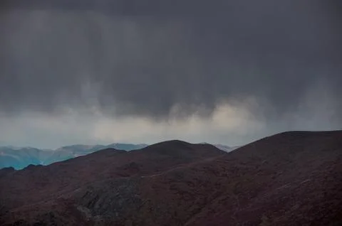 Severe clouds against the backdrop of mountains in the Altai Mountains Stock Photos
