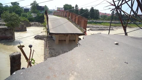 Severe flood damage to bridge and road in Dehradun India Stock Footage 321040235