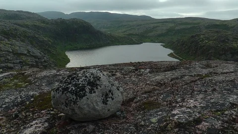 Severe granite mountains under a cloudy sky and a lake in the distance. Stock Footage 74481941