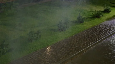 Severe rainfall with strong wind occurs on night pavement Stock Footage 238469041