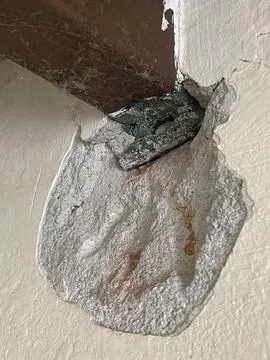 Severe wall damage with peeling plaster exposing inner structure close-up Stock Photos