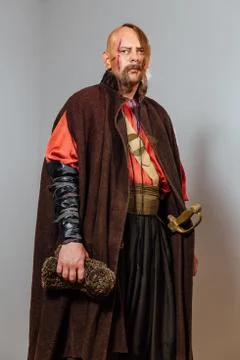 Severe warrior Russian Cossack, face in scars, bald. Bled blood. Saber in sheath Stock Photos