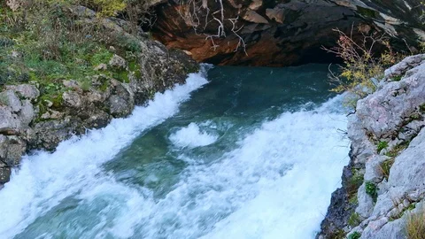 Severe waterfall stream flowing from cave surrounded by rocks Stock Footage 121520335