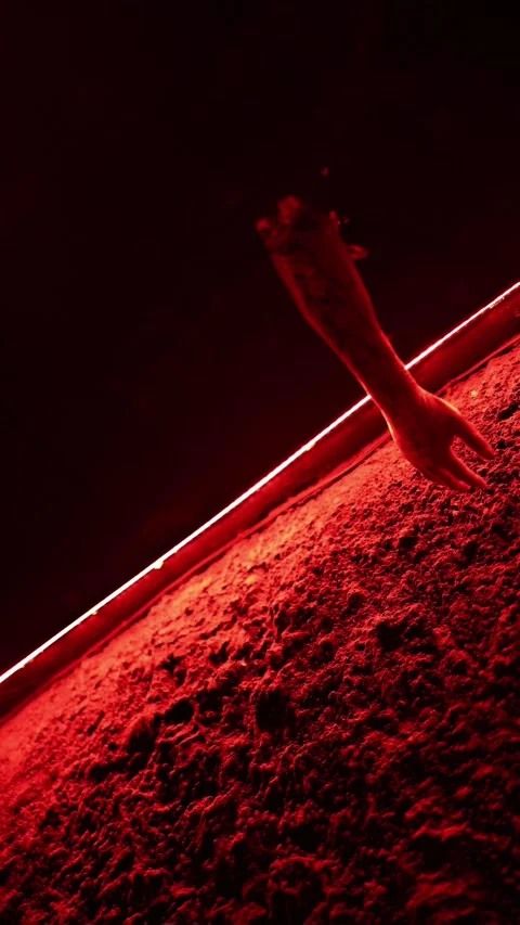 Severed arm hangs from ceiling under intense red Halloween horror lighting 库存影片 345598610