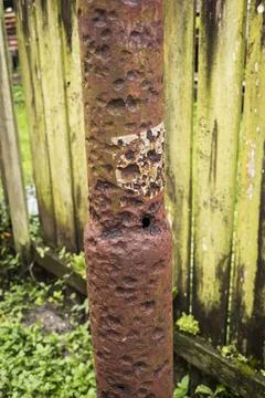 Severely corroded metal post with rust damage in tropical climate Stock Photos