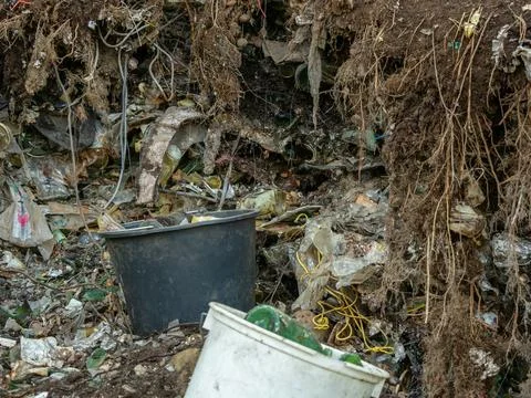 Severely Polluted Soil with Unearthed Plastic Waste and Roots Stock Photos