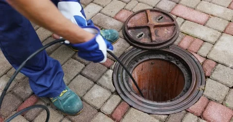 Sewer cleaning service - worker clean a clogged drainage with hydro jetting Stock Footage 202264943