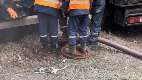 Sewer cleaning workers clean sewers using a vacuum hose and special equipment Stock-Footage 303621848