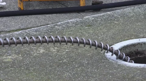 Sewer drain cleaning, snake going down hole and monitor Stock Footage 59737994