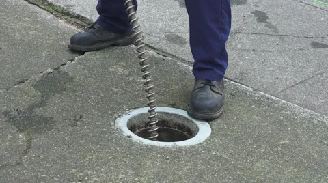 Sewer drain cleaning, using foot to start snake Stock Footage 59737855