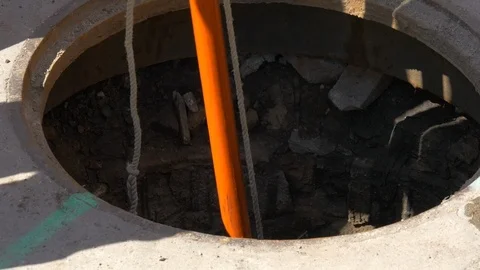 Sewer man hole with cable passing through from sewer maintenance truck. Stock Footage 107003657