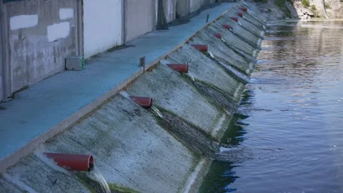 Sewer pipes through which waste is drained into the river Stock-Footage 248533873