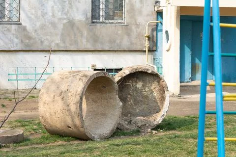 Sewer ring. Broken sewer ring covered with clay and sand on the lawn near the Stock Photos