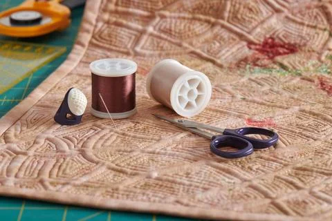 Sewing accessories lying on a reverse side of a quilt, cutting mat, ruler, .. Fotos de archivo