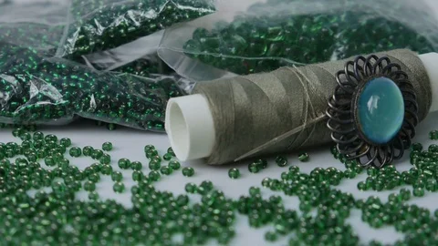 Sewing Accessories Macro. Green Beads,  Beautiful green gem on a brooch Close up Stock Footage 123073641