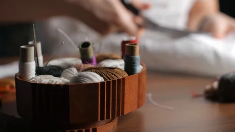 Sewing accessories - multi-colored threads, pins, casket. Hands of a young dr Video stock 128363432