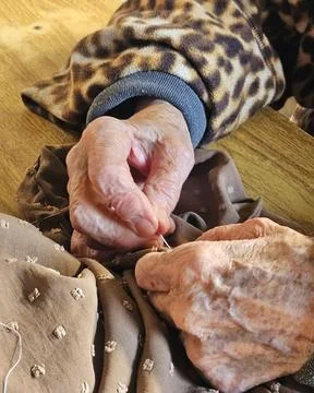 Sewing with aged hands Stock Photos