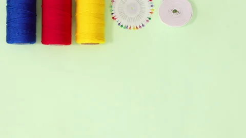Sewing and knitting threads, buttons scissors appear on the top. Stop motion Stock Footage 154971365