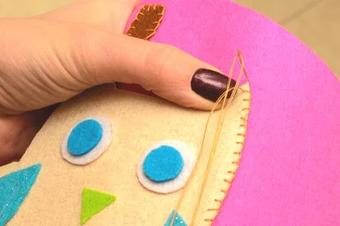 Sewing application of a owl of felt with a thread and a needle Stock Photos