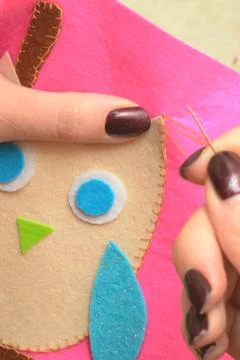 Sewing application of a owl of felt with a thread and a needle Stock Photos