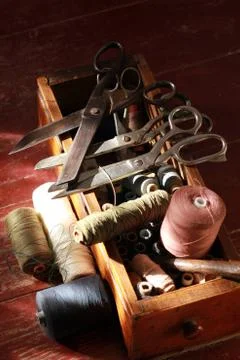 Sewing box with many thread spools and vintage scissors Stock Photos