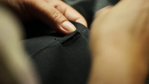 Sewing a button onto a bespoke tailored suit Stock Footage 71531482