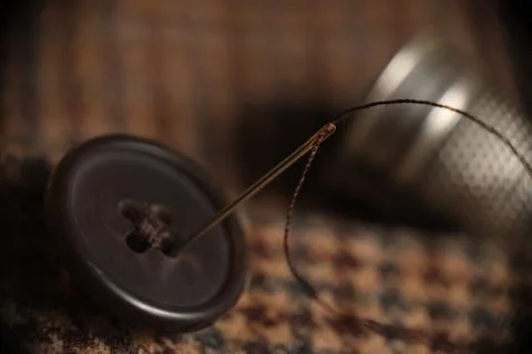 Sewing button on a tweed coat Stock Photos