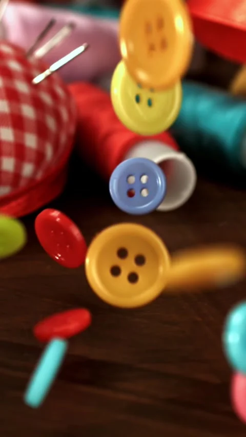 Sewing buttons fall on a wooden table. Filmed on a high-speed camera at 1000 fps Stock Footage 335369166