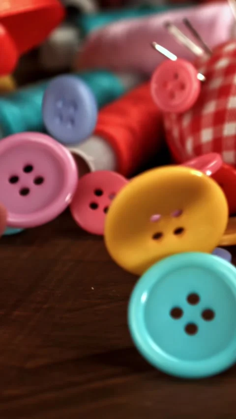Sewing buttons fall on a wooden table. Filmed on a high-speed camera at 1000 fps Stock Footage 335372309