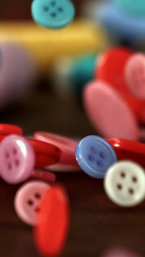 Sewing buttons fall on a wooden table. Filmed on a high-speed camera at 1000 fps Stock Footage 335374193