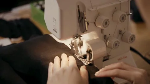 Sewing Close-up Hands Using Serger Machine for Fabric Work Stock Footage 301953155