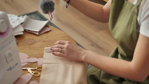 Sewing clothes for handmade dolls, master marks out the details on the fabric Stock Footage 230993244