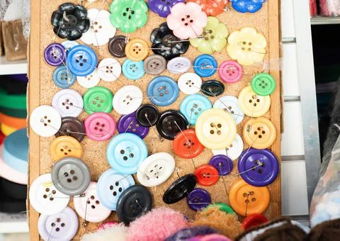 Sewing colourful difference buttons on the table Stock Photos