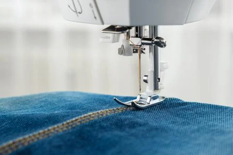 Sewing denim jeans with sewing machine. Close up of needle of sewing machine  Stock Photos