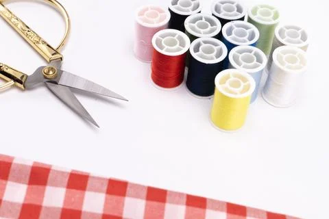 Sewing Essentials - Colorful Thread Spools, Scissors, and Red Gingham Fabri.. Stock Photos