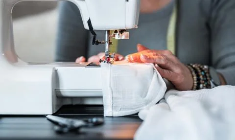 Sewing a Garment on a White Machine in a Workspace Stockfoto's