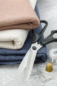 Sewing items: fabrics, tailoring scissors, tape measure for sewing clothes. Stock Photos