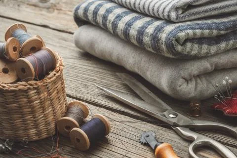 Sewing items: retro tailoring scissors, thimble, cutting knife, basket with w Stock Photos