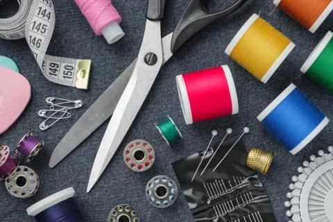 Sewing items: tailoring scissors, measuring tape, thimble, threads, needles.  Stock Photos