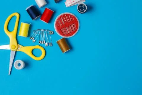 Sewing items: tailoring scissors, measuring tape, spools of multicolored thre Stock Photos